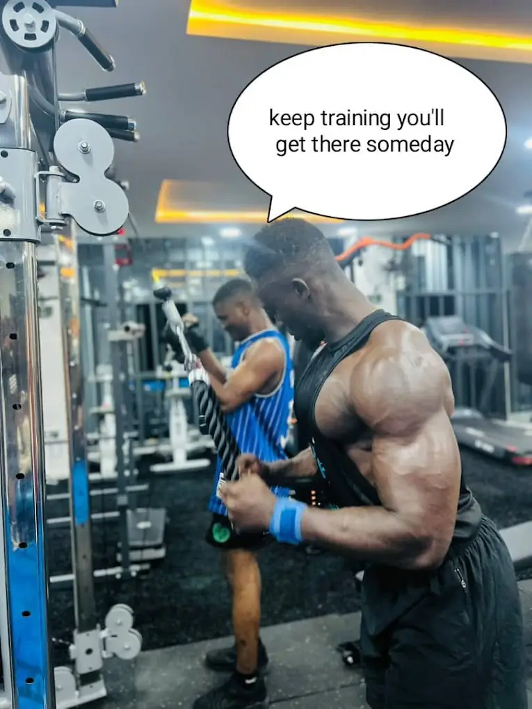 Savfol coach spotting a member through a cable row, with the speech bubble "keep training, you'll get there someday"